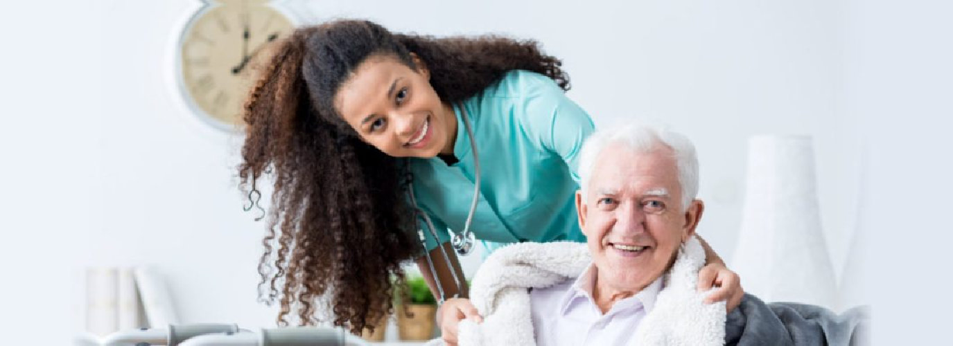 female caregiver and senior man smiling indoor